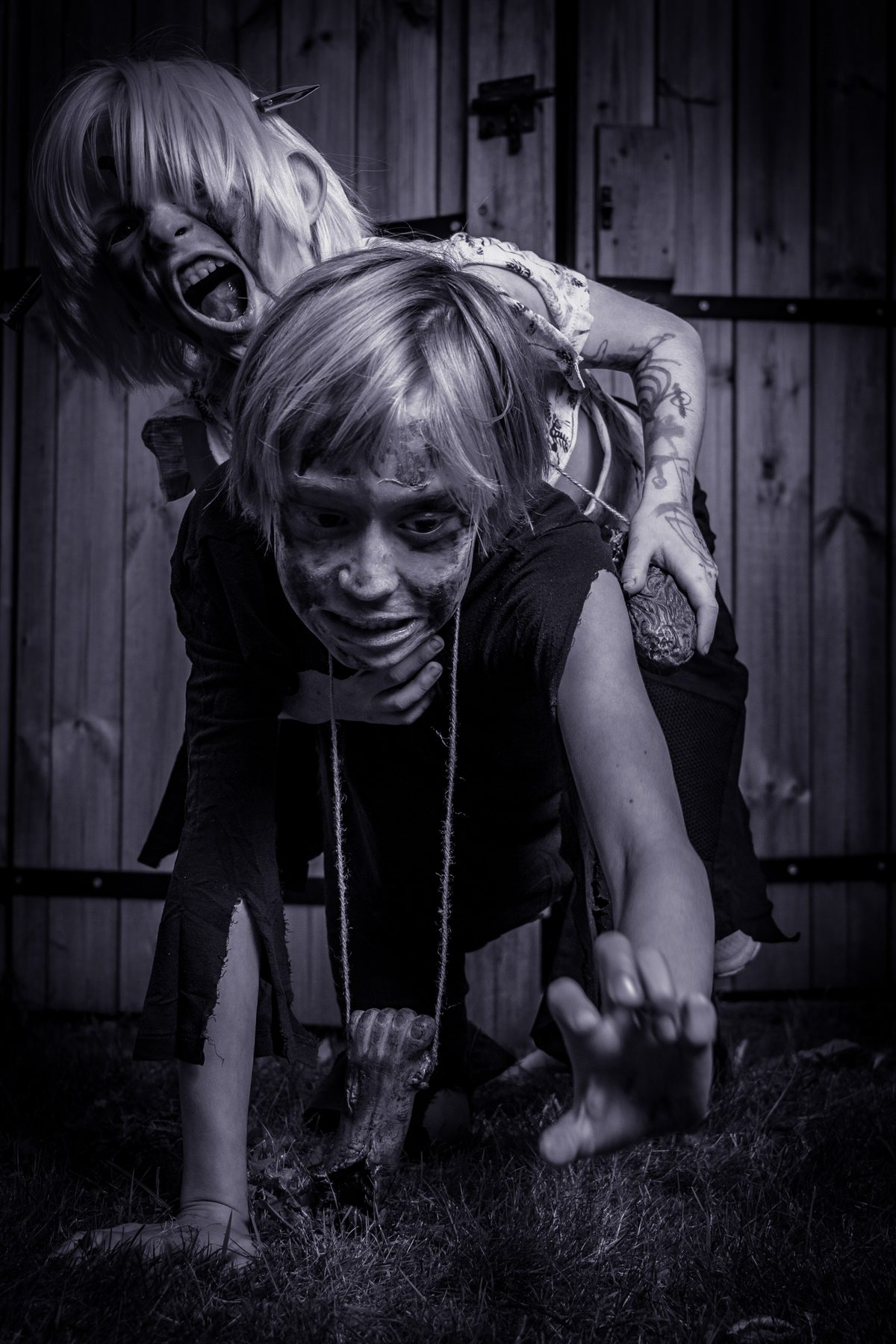 Two zombie kids crawling towards the camera, in black and white.